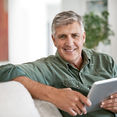 Portrait of a mature man using a digital tablet at home
